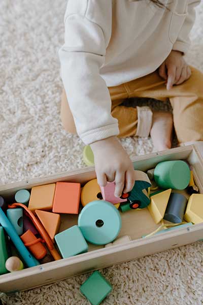 child playing with wood blocks